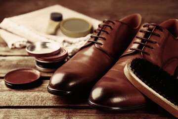 Shoe care accessories and footwear on wooden background