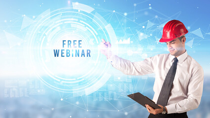 Handsome businessman with helmet drawing FREE WEBINAR inscription, contruction business concept