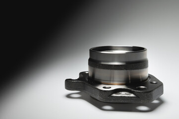 New wheel bearing in a metal housing on a black-white gradient background. New car suspension parts