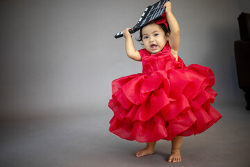 Lovely cute little Asian girl in a red dress is playing merrily and happily in her own home, promoting her skills and creativity..