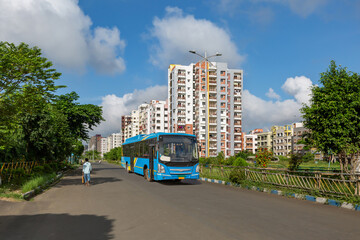 Public transport bus on city road with residential buildings at New Town area Kolkata © Roop Dey