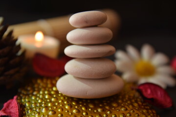 Obraz na płótnie Canvas meditazione zen terapia con pietre luci di candela atmosfera e fiori su sfondo nero