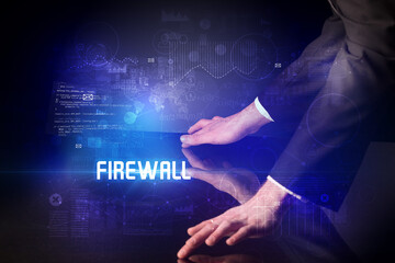 Hand touching digital table with FIREWALL inscription, new age security concept