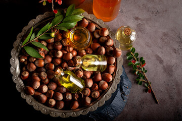 Concept of organic vegetable oils for cooking and cosmetology. Hazelnut oil and fresh nuts.