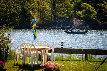 the table is set, the Swedish flag is hoisted and behind it passes a small boat with fishermen