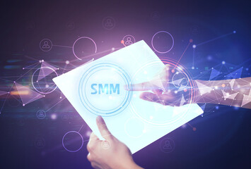 Hand holdig futuristic tablet with SMM inscription, modern technology concept
