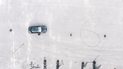 practical driving test. student on a black car bypasses obstacles. slalom by car between tires. aerial view. driving training area, driving course. Driving lessons training. top shot