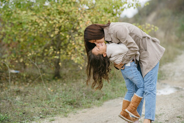 Sensual photo. Cute little girl. People walks outside. Woman in a brown coat.