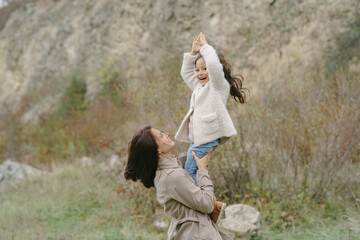 Sensual photo. Cute little girl. People walks outside. Woman in a brown coat.