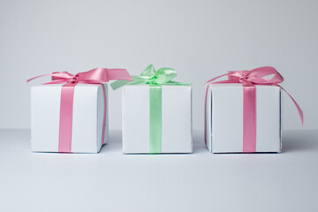 White gifts with pastel mint and pink ribbons. Set of gift box isolated on white background.Christmas gift boxes on white background. Beautiful Christmas background with shiny balls and ribbons.