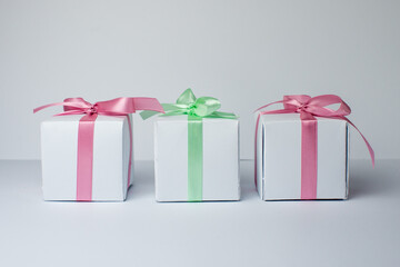 White gifts with pastel mint and pink ribbons. Set of gift box isolated on white background.Christmas gift boxes on white background. Beautiful Christmas background with shiny balls and ribbons.