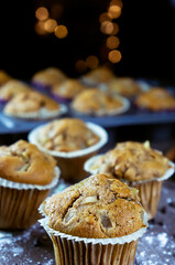 close up of delicious hand-made muffins decorated with a star-shaped pear, sugar and chocolate pear in festive atmosphere and colored lights.