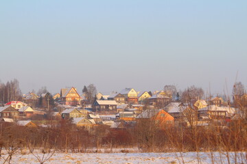 Fototapeta na wymiar Elegant multi-colored wooden village houses on a clear winter day.