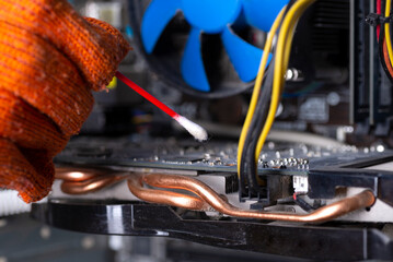 Internal parts of an old personal computer. Dusty motherboard and video card. The wizard cleans the...