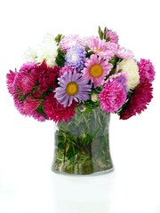 multicolor asters flowers in glass vase close up