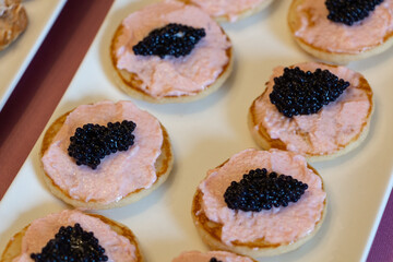 Blinis with taramasalata and lump-fish roe on a white dish