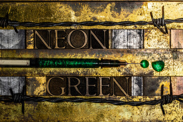Neon Green text lining syringe filled with green fluid flanked by barbed wire on textured grunge copper and gold background