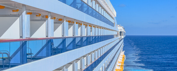 Vue d'un navire de croisière et des cabines balcons en navigation sur la mer.	