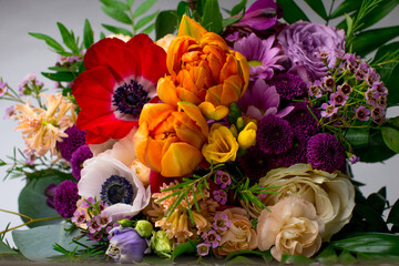 Colorful bouquet of fresh spring flowers on white background. Colorful blooming flowers: tulips, peonies, roses in a spring bouquet. Background, place for text. Wedding bouquet.