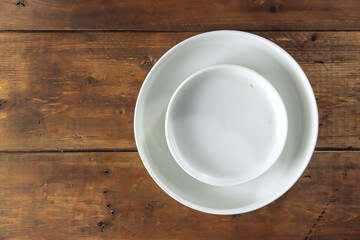 Fototapeta na wymiar Tableware: white empty plate isolated on the wooden table