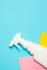 Microfiber cloth and spray cleaner on a blue background, top view, copy space. Cleaning supplies.