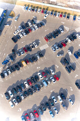Cars are put in even rows on the places for parking a large parking lot near the supermarket - the...