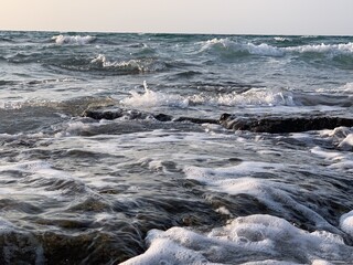 Rocks in the sea with a foaming wave. Netanya, Israel