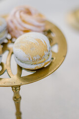 Fototapeta premium Modern trendy macaroon dessert on a gold stand close up