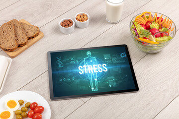 STRESS concept in tablet with fruits, top view