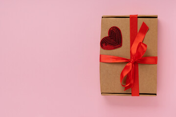 Valentine day composition: craft gift box with red heart on pink background.Top View. View from above.