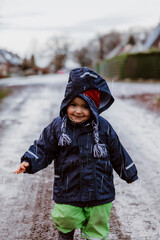 Toddler girl running on footpath with raindrops