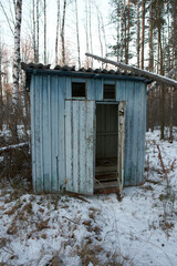 Old wooden outhouse in the forest.