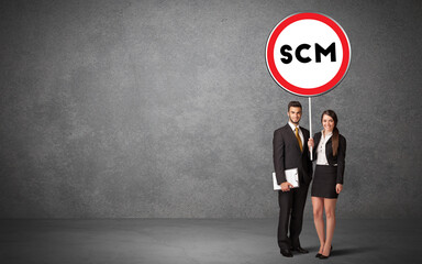 Young business person holdig traffic sign with SCM abbreviation, technology solution concept