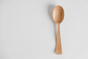 Empty wooden spoon on a white background. Top view. Copy, empty space for text