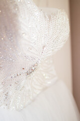 Fototapeta na wymiar A close up of a bride's white wedding dress with rhinestones