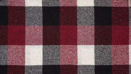 Texture of a woolen red-black-white plaid in a cage, close-up of fabric, textile winter...