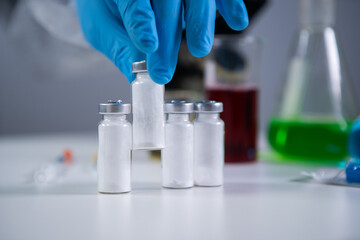 Exploring Covid 19 medicinee. Vaccine bottle for COVID-19 coronavirus in researcher hand. Medical...