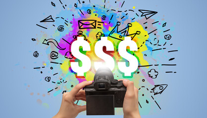 Close-up of a hand holding digital camera with abstract drawing and $$$ inscription