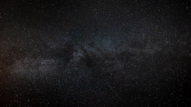 A meteorite explodes into stardust during a timelapse of a meteor shower with the Milky Way galaxy in the background.