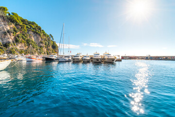 Boats line the Fontvieille Harbor near the Rock of Monaco as the sun starts to set on the Mediterranean Sea.