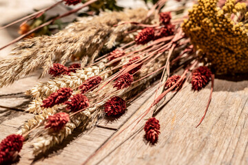 Naklejka premium Dry herbs, flowers and spikelets on a wooden surface.