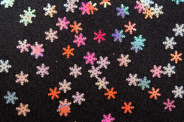 multicolored christmas confetti isolated on black background