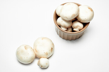 White mushrooms champignons on a light background.