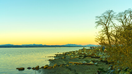 Golden sunset over distant North Shore mountains, seen from Boundary Bay, BC - early winter
