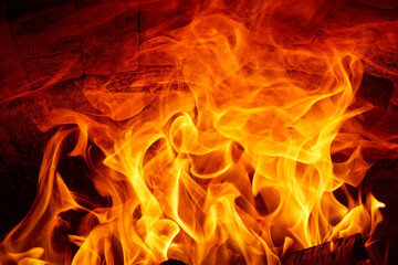 Fototapeta premium Burning fire flames on a dark background in a wood stove.