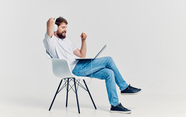 Man sitting on a chair in front of laptop headphones rest office internet technology