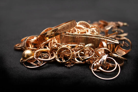 Scrap gold jewelry. Pile of old used gold jewelry on black background.