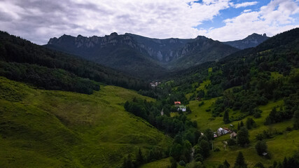 Fototapeta premium Mount Ceahlau seen from Izvoru Muntelui. Mount Ceahlau with meadows and houses at its base