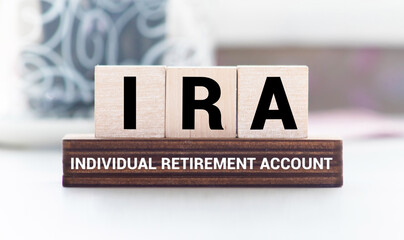 IRA individual retirement account word on wood cube block with blue background