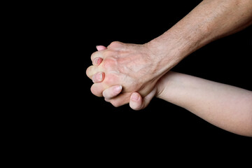 male and female hands together on black background, old skin with wrinkles and veins, concept of health, age-related changes, love, tender relationship of a couple in love, isolated image
